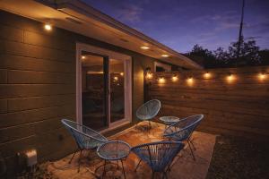three chairs and a table on a patio with lights at Pet Friendly Stylish Condo Near Campus in Gainesville