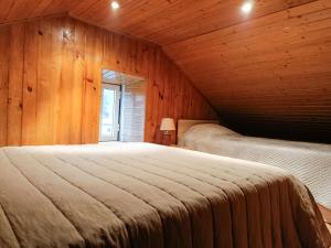 a bedroom with two beds in a wooden cabin at Casa do Padrinho in Teixeira de Baixo