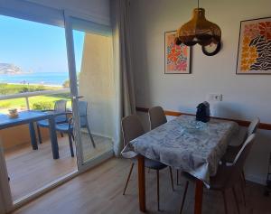 a dining room with a table and a view of the ocean at Apartamento Estartit Argonavis in L'Estartit