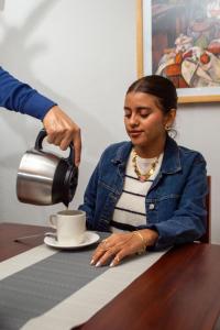 a woman sitting at a table drinking a cup of coffee at Casa Nieto in Teotitlán del Camino +44 photos