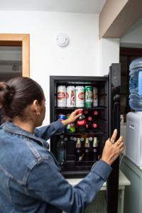 a woman is looking inside of an open refrigerator at Casa Nieto in Teotitlán del Camino