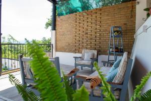 a patio with chairs and a table and a brick wall at Casa Nieto in Teotitlán del Camino