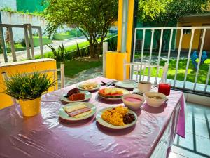 a pink table with plates of food on it at Pousada Granville in Campina Grande +21 photos