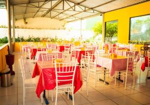 a restaurant with tables and chairs with red table cloths at Pousada Granville in Campina Grande