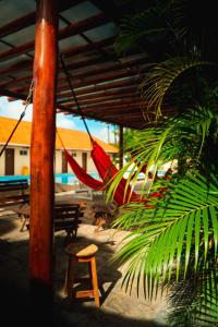 a red hammock hanging from a building with a palm tree at Pousada Granville in Campina Grande