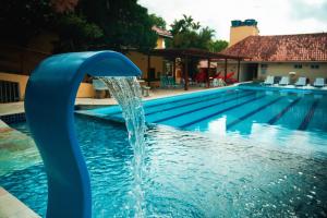a blue water fountain in a swimming pool at Pousada Granville in Campina Grande