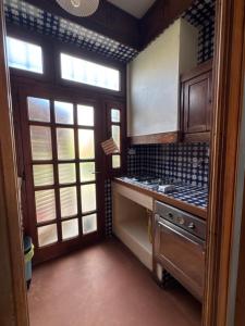 a kitchen with a stove and a sink and windows at Villa Elettra in Pisa