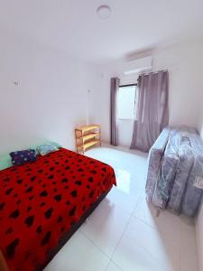 ein Schlafzimmer mit einer roten Bettdecke auf einem Bett in der Unterkunft Casa Riso Dourado in Paracuru + 27 Fotos