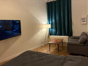 a living room with a couch and a table and a chair at Duplex with Jacuzzi - Grand place Arras in Arras