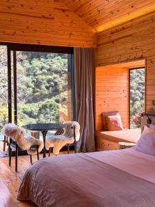 a bedroom with a bed and a table and chairs at Vale Sagrado in Urubici +62 photos