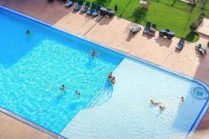 a group of people in a large swimming pool at Cosmo Iris in Ştefăneştii de Sus