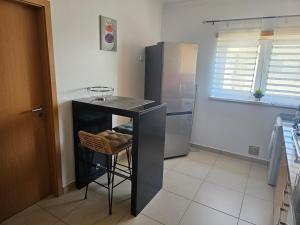 a kitchen with a counter and a refrigerator at Brisa do Mar in Leiria