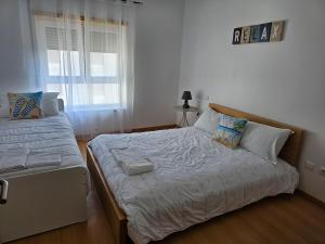 a bedroom with a large bed and a window at Brisa do Mar in Leiria