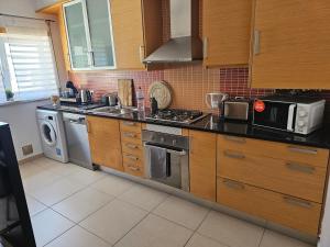 a kitchen with a stove and a microwave at Brisa do Mar in Leiria