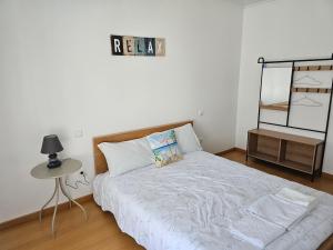 a bedroom with a bed and a table and a mirror at Brisa do Mar in Leiria +24 photos