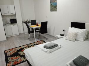 a bedroom with a bed and a table and chairs at Studio apartman Sokak in Bihać