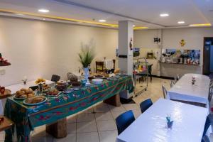 a dining room with a table with food on it at GB Hotéis Foz Rodoviária in Foz do Iguaçu