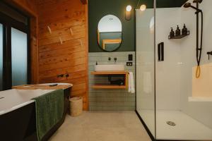 a bathroom with a tub and a sink and a mirror at Surfwatch House in Kaikoura