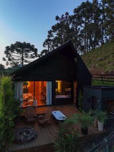 a house with a deck with chairs and a fire pit at Vale Sagrado in Urubici