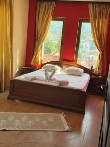 a bedroom with a bed with a red wall at Hotel Paradise in Kyustendil