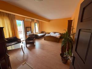 a living room with a bed and a couch at Hotel Paradise in Kyustendil