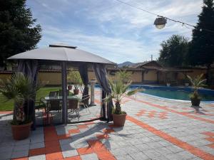 a patio with a table and an umbrella next to a pool at Hotel Paradise in Kyustendil