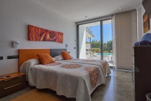 a bedroom with a bed with orange pillows on it at Can Anara in Cala Llena