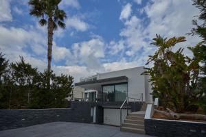a white house with a palm tree and stairs at Can Anara in Cala Llena