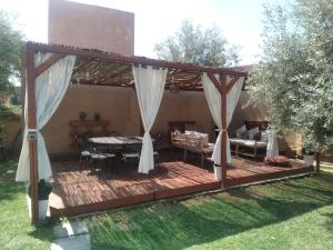 a wooden deck with a table and chairs on it at Villa Dar Daraa with Pool in Najem