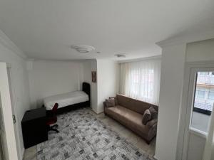 a living room with a couch and a bed at BR Konaklama in Göztepe