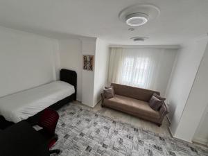 a bedroom with a bed and a couch and a window at BR Konaklama in Göztepe