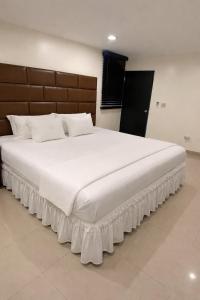 ein großes Bett mit weißen Laken und Kissen in der Unterkunft Starz Hotel Corporate lodging in Nazareth + 3 Fotos