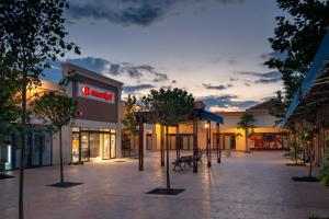 a mall with a walmart sign and trees in front at Cosmo Iris in Ştefăneştii de Sus
