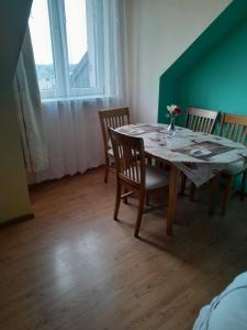 a dining room with a table and chairs and a window at Apartament Przytulny in Ogrodzieniec