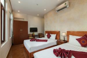 a hotel room with two beds and a television at Luxury Airport Hotel Travel in Sóc Sơn +24 photos