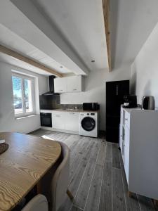a kitchen with a table and a white refrigerator at Maison avec Jacuzzi Privatif Calme Soleil Cote d Azur in La Crau