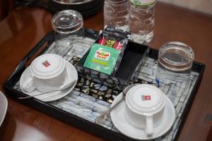 a tray with plates and dishes on a table at Luxury Airport Hotel Travel in Sóc Sơn