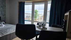 a bedroom with a table and chairs and a window at Totall Panoramic Studio in Moreni