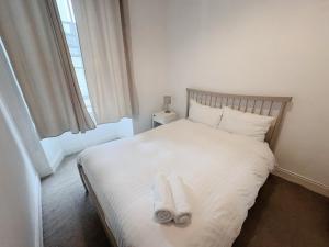 a bedroom with a white bed with towels on it at Edinburgh Town Apartment in Edinburgh +2 photos