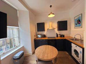 a kitchen with a wooden table and a sink at Edinburgh Town Apartment in Edinburgh