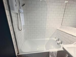 a white bathroom with a tub and a sink at Edinburgh Town Apartment in Edinburgh