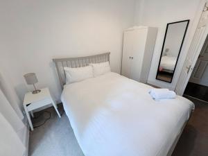 a bedroom with a white bed and a mirror at Edinburgh Town Apartment in Edinburgh