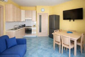 a kitchen with a table and a blue couch at Variopinto Home in Ischia Town