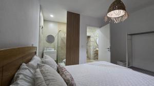 a bedroom with a large white bed and a chandelier at Malu in Pinhal do Douro