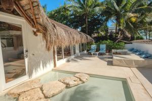 a swimming pool next to a house with a patio at Cabanas Tulum- Beach Hotel & Spa in Tulum