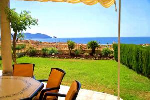 a patio with a table and chairs and the ocean at Casa Elletofft in Puerto de Mazarrón