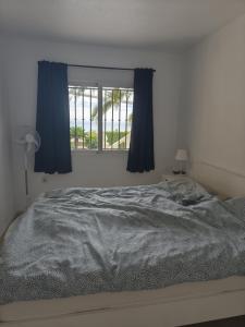 a bedroom with a bed with blue curtains and a window at Casa Elletofft in Puerto de Mazarrón