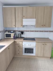 a kitchen with wooden cabinets and a white appliance at Casa Elletofft in Puerto de Mazarrón +6 photos