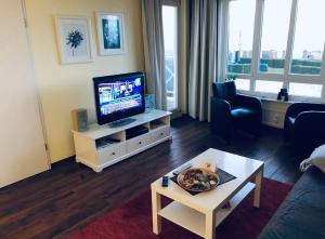 a living room with a television and a table at Ocean View Laboe in Laboe