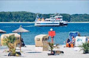 a boat on the water with people on the beach at Ocean View Laboe in Laboe